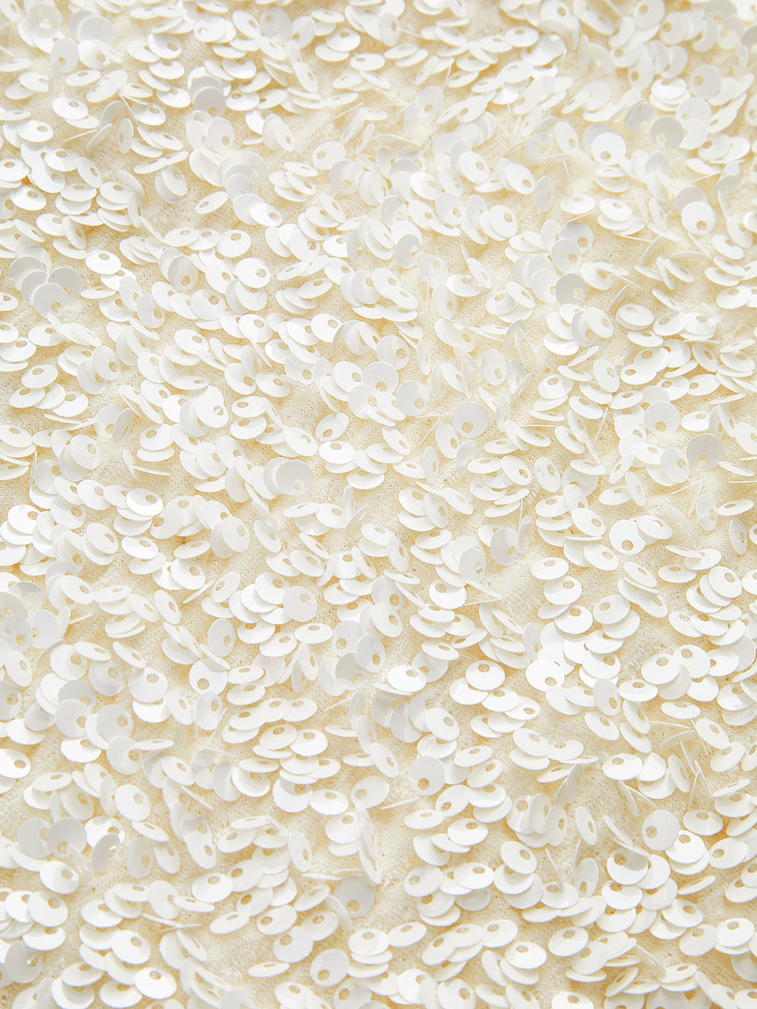 Macro of the pearlescent ivory sequins covering the jacket