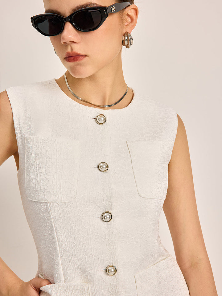 Close-up of white vest showing patch chest pockets and engraved silver buttons