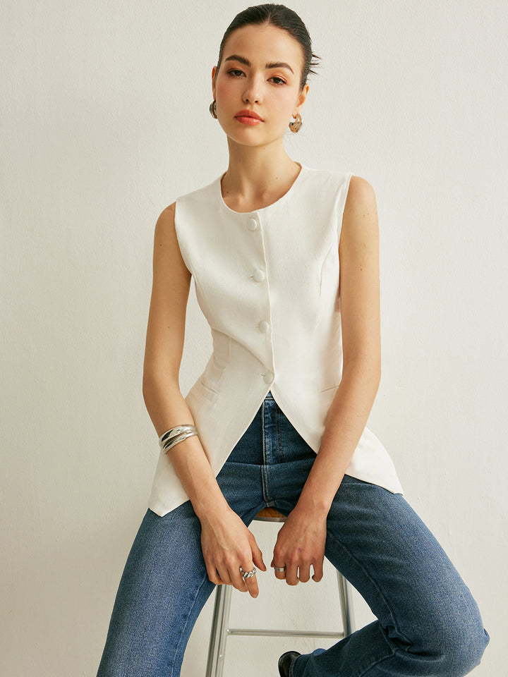 White linen sleeveless vest with covered buttons and split hem, worn with blue jeans