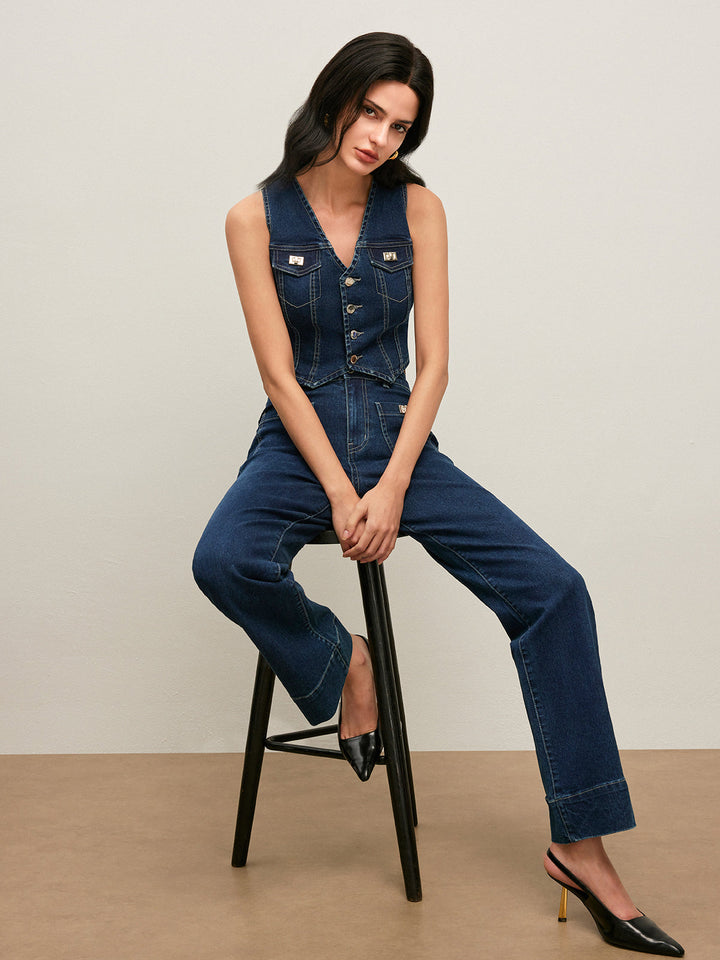 Model seated on a stool in cropped denim vest and matching blue jeans
