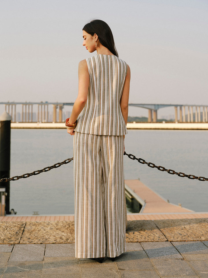 Back view of beige striped linen vest and wide-leg trouser co-ord by the water