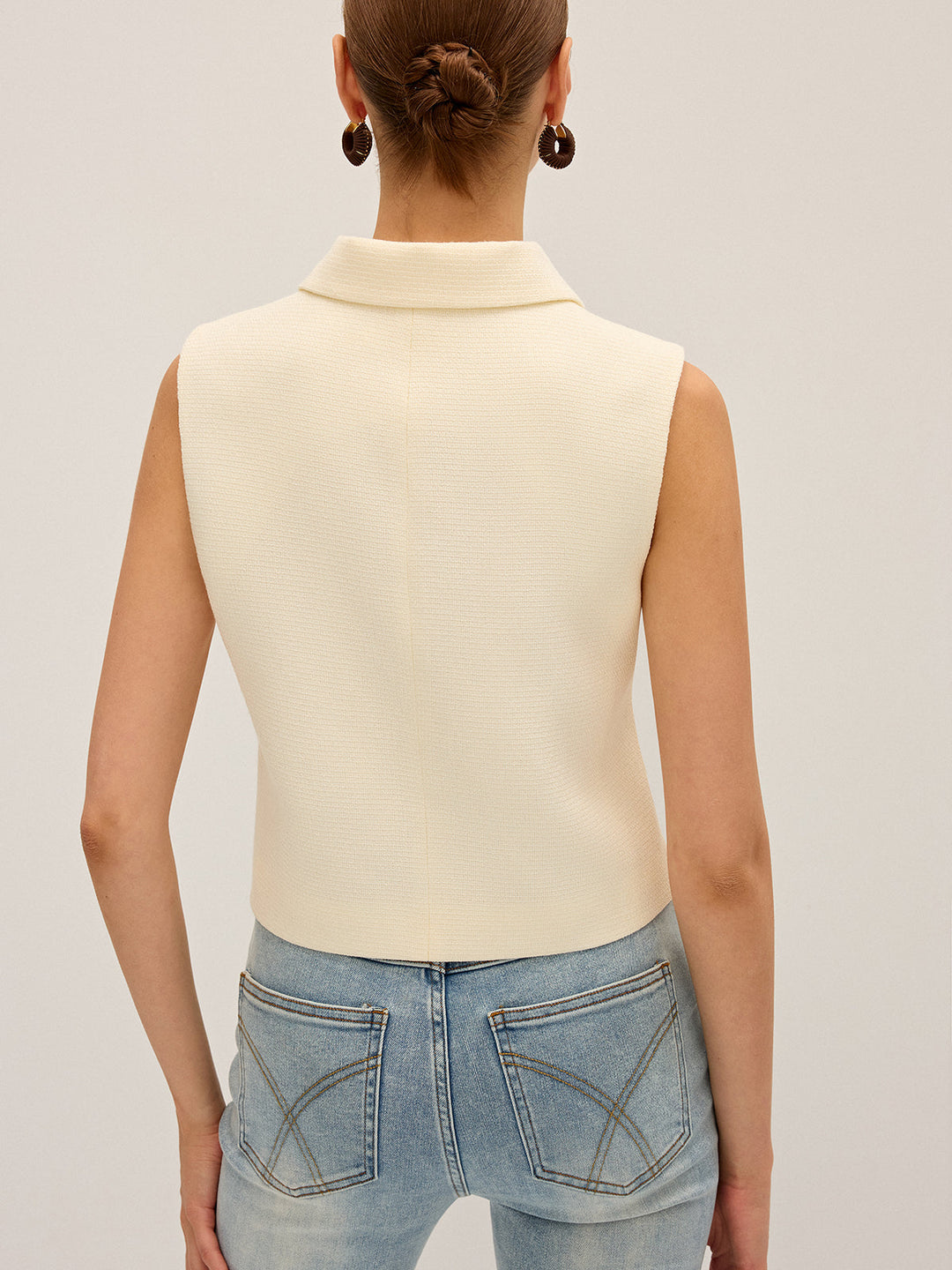 Back view of the off-white sleeveless vest showing the collar and clean cropped back