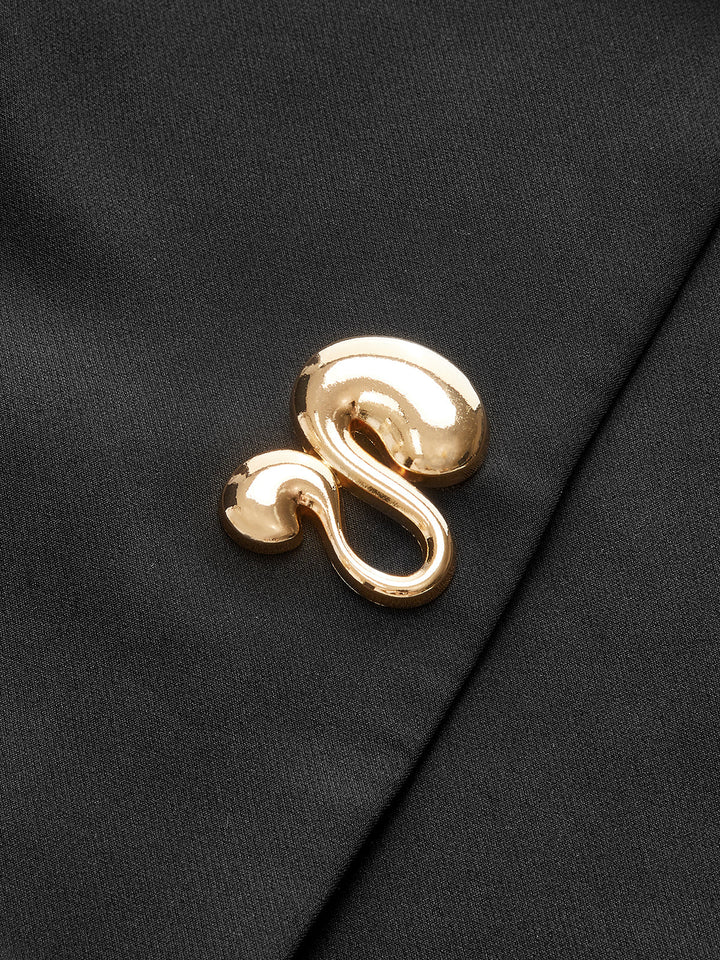 Macro of the polished gold swirl button detail on the black cap sleeve vest