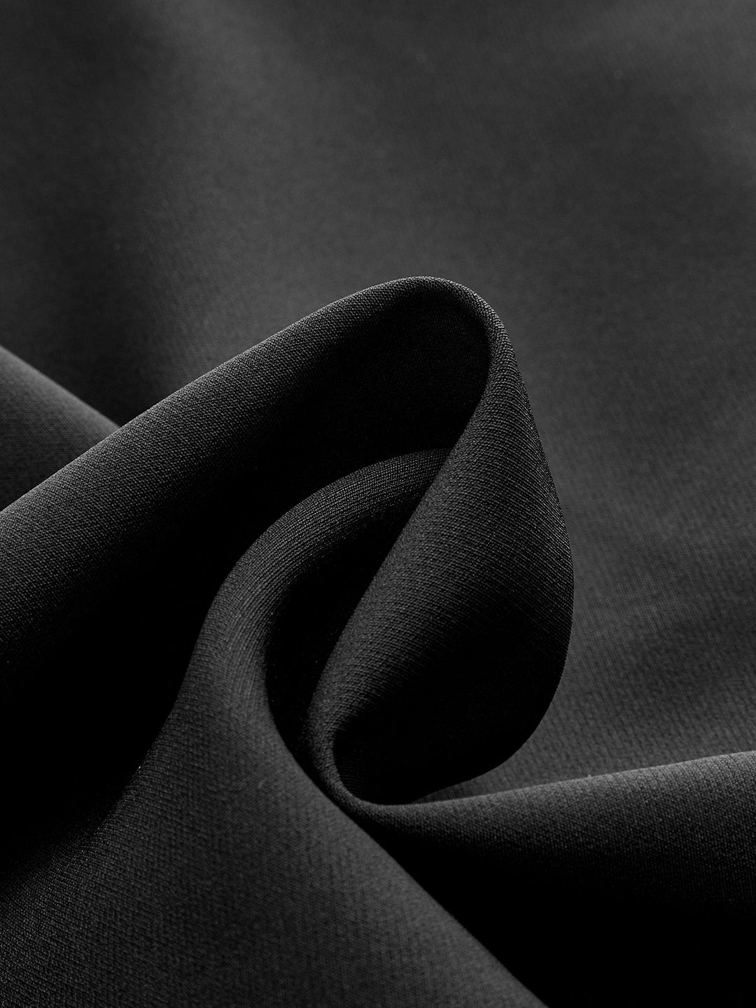 Close-up of the draped black crepe fabric of this women's metal detail cap sleeve vest