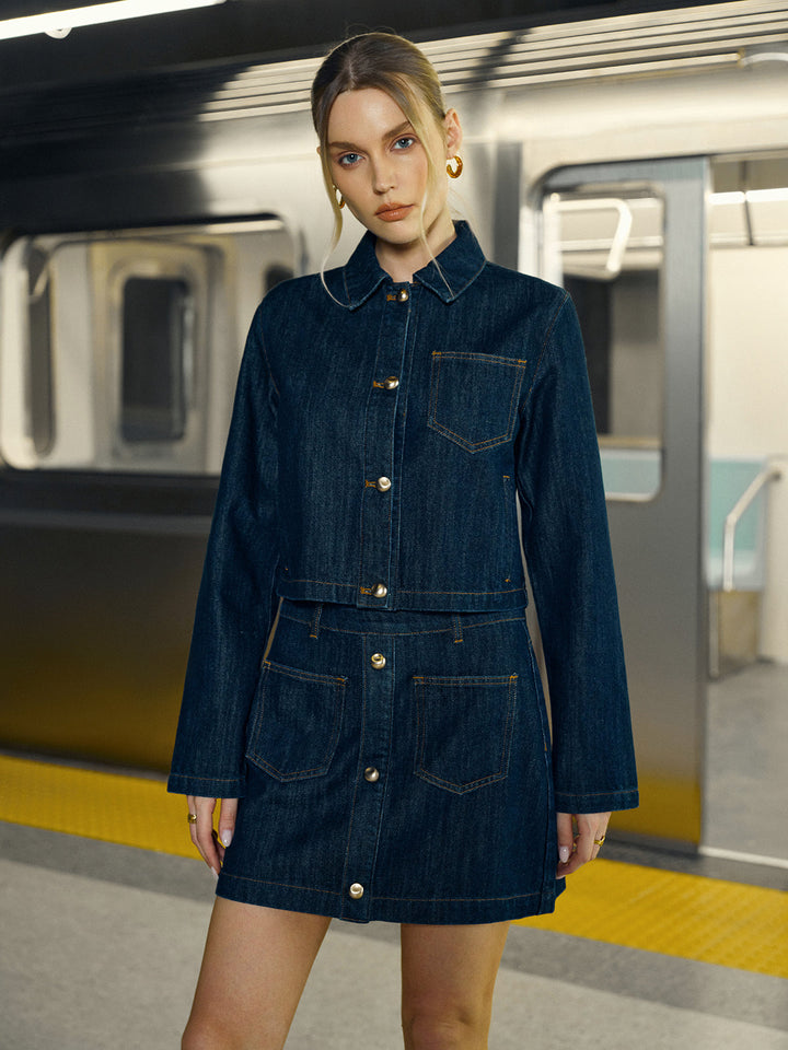 Model on subway platform in dark indigo cropped denim jacket with matching mini skirt