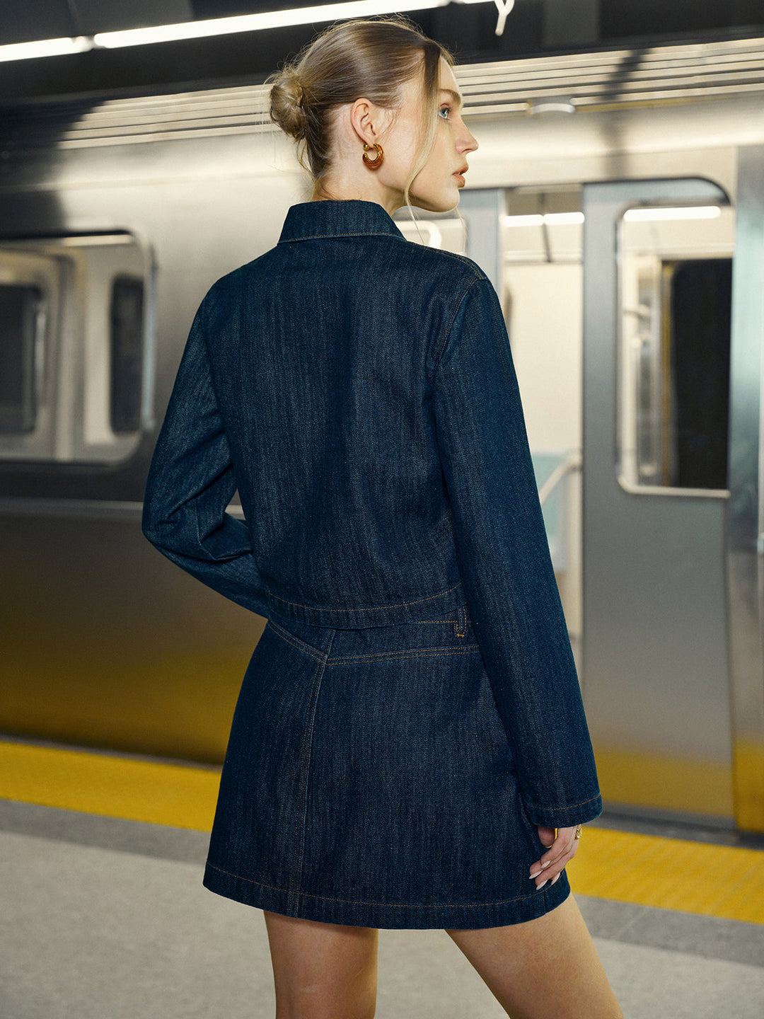 Back view of cropped denim jacket and denim mini skirt co-ord in deep indigo wash