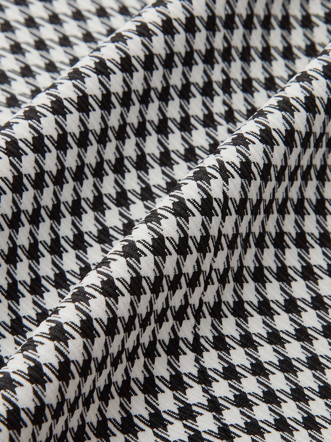 Draped detail of the monochrome houndstooth weave of the women's sleeveless vest
