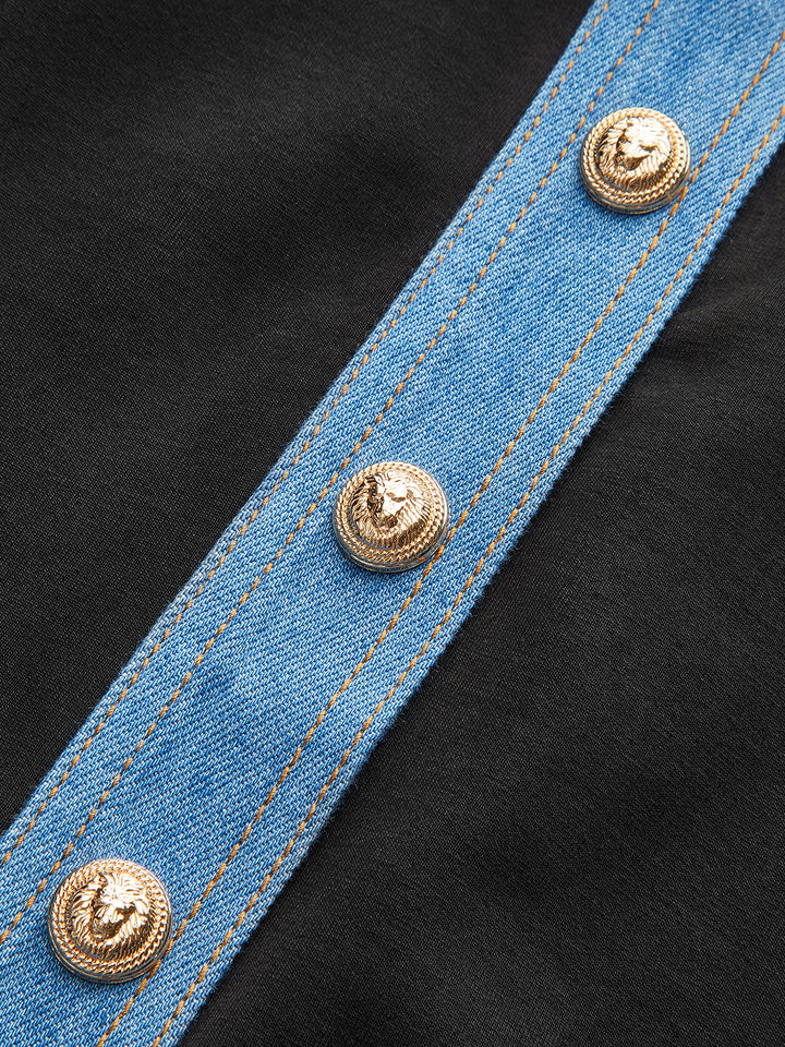 Close-up of the gold lion buttons on the blue denim placket over black fabric