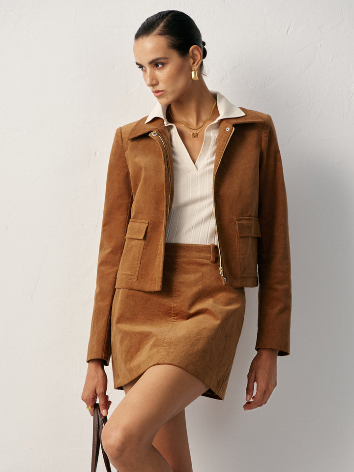 Front view of caramel corduroy jacket worn open over a cream knit top