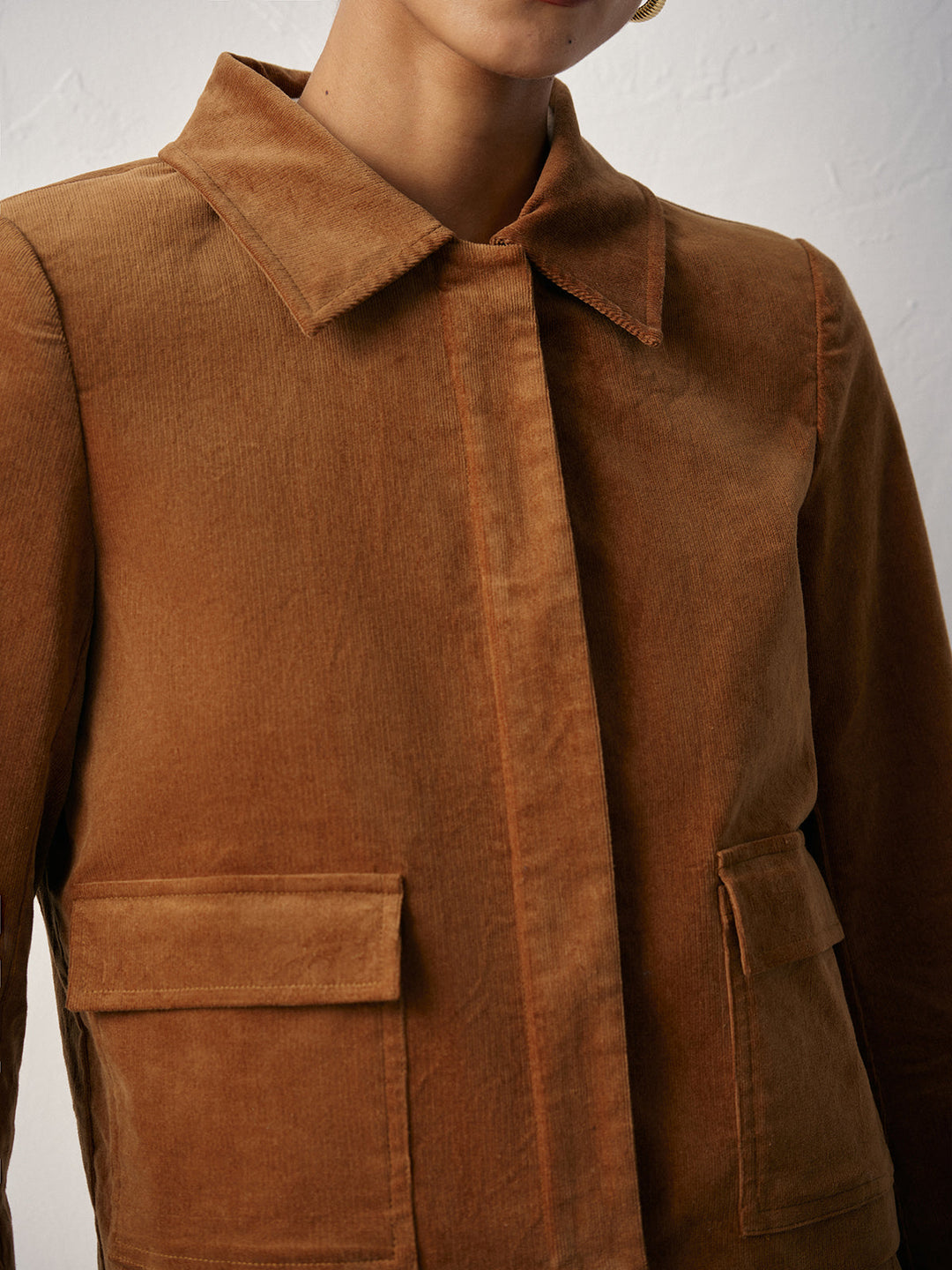 Close-up of pointed collar and flap patch pockets on a camel corduroy jacket