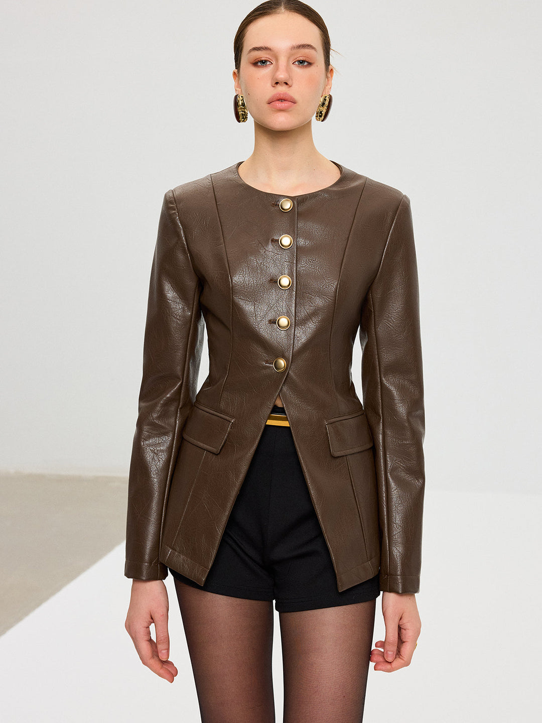 Straight-on view of dark brown metal button fitted faux leather jacket