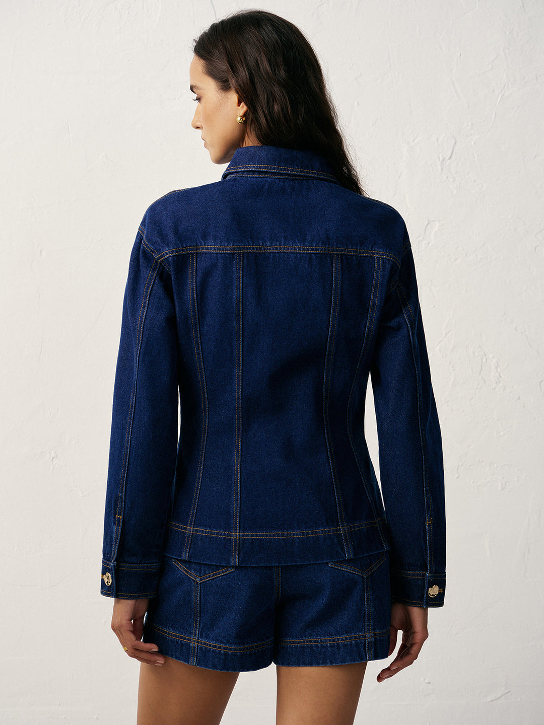 Back view of cinched waist denim jacket with shoulder yoke and vertical seam shaping