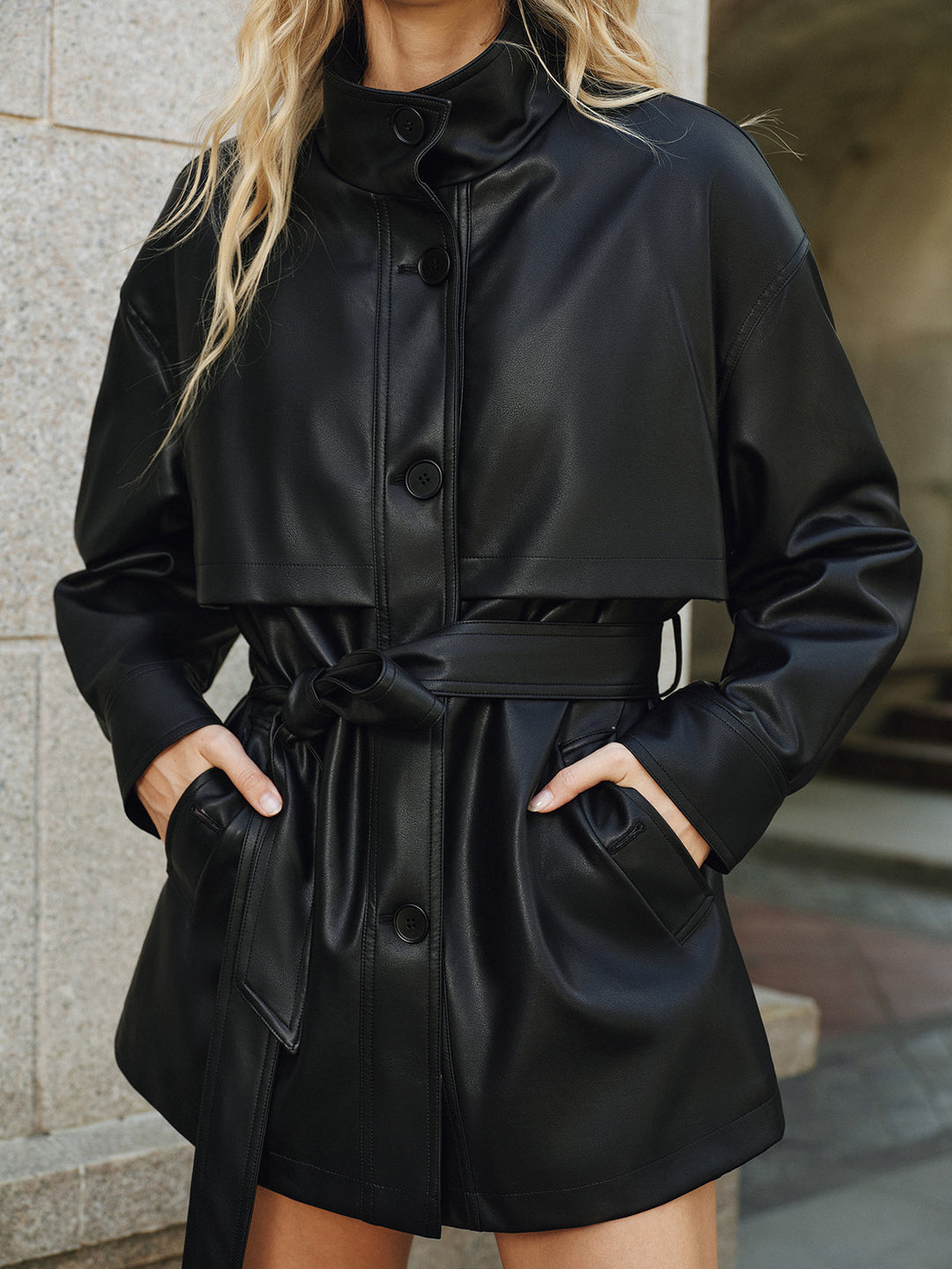 Front view of black stand collar PU leather jacket with tie belt and slanted pockets