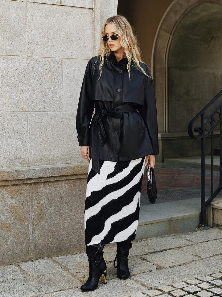Black belted faux leather jacket styled with a black and white striped midi skirt