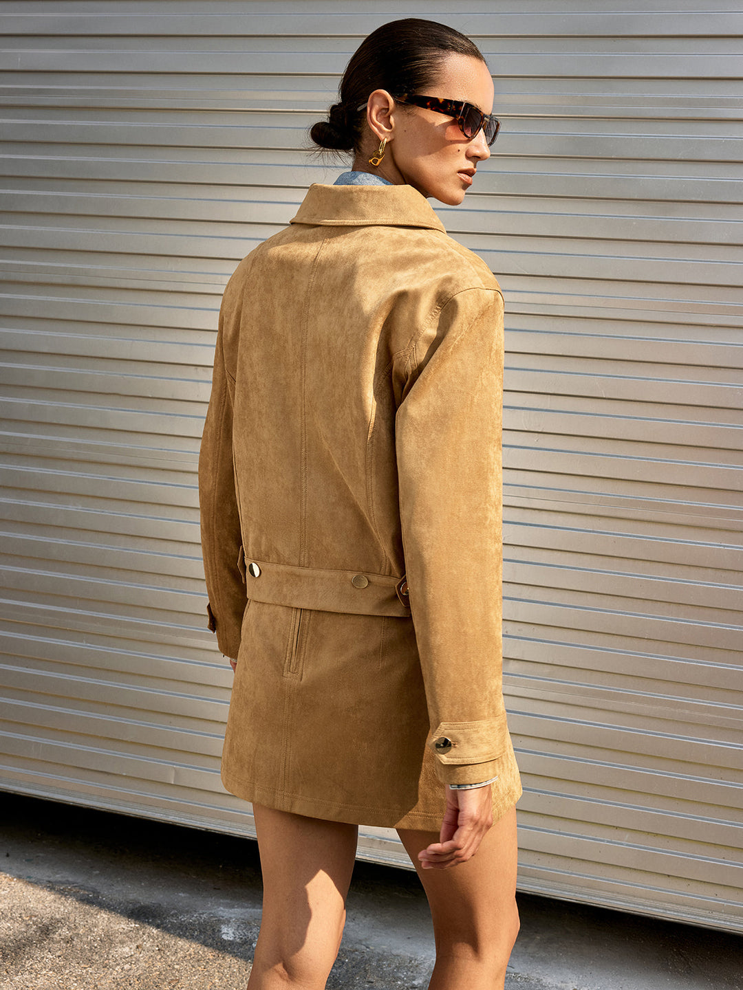 Back view of the tan suede jacket with box pleat and matching suede skirt