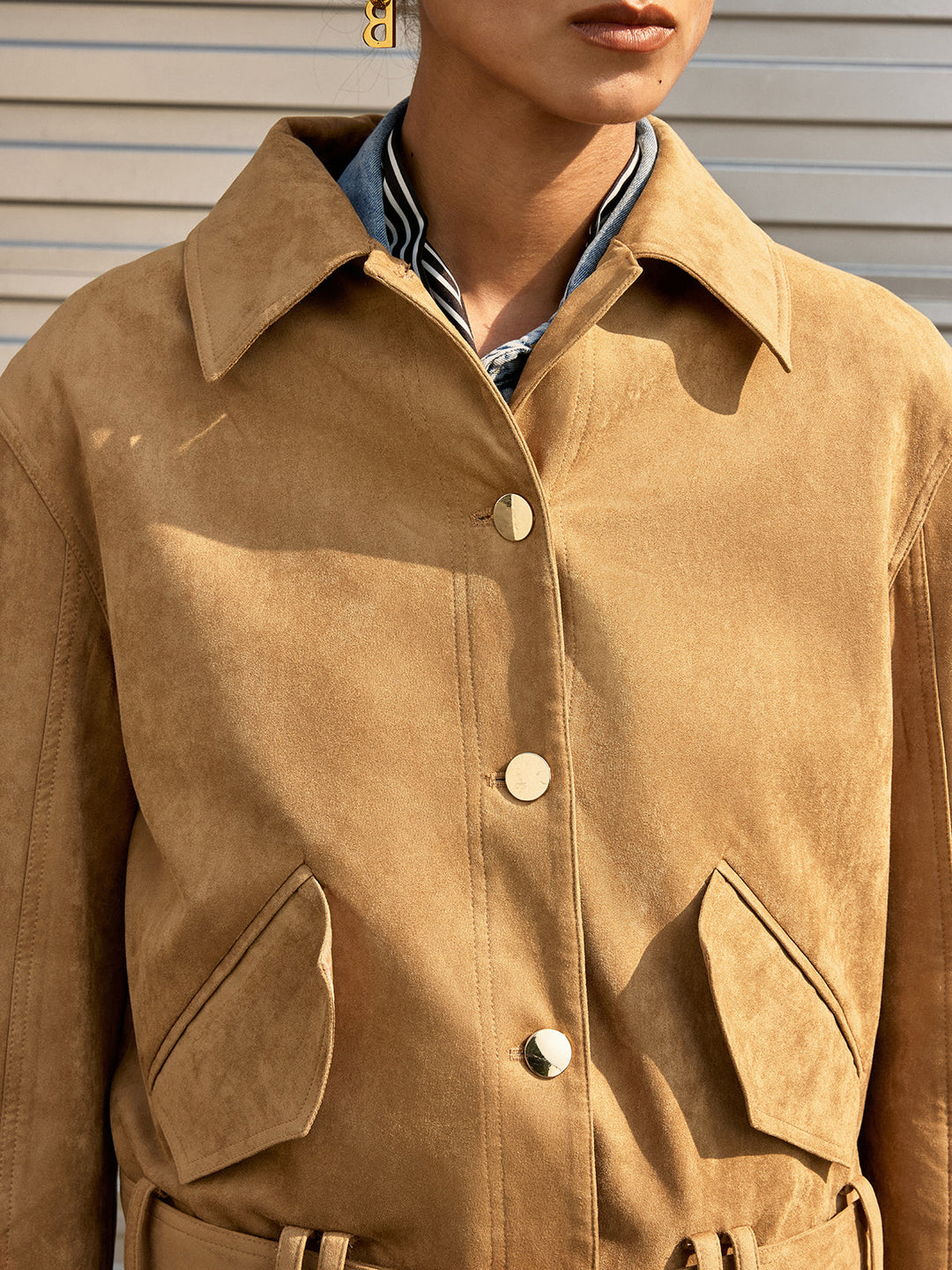 Close-up of the pointed collar and gold buttons on the khaki suede jacket