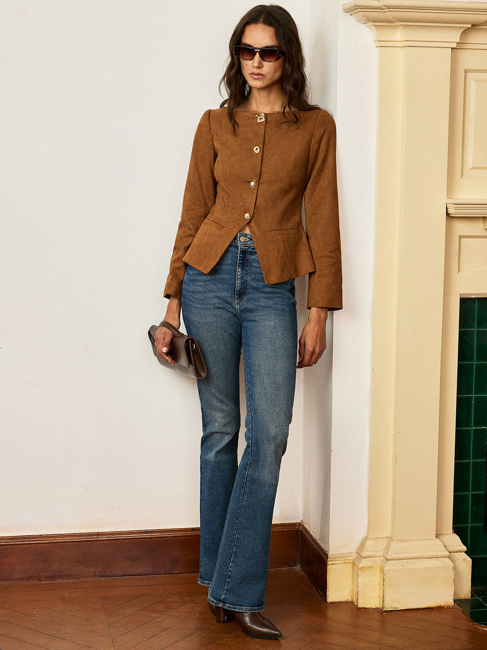 Full length shot of the brown suede peplum jacket with flared jeans in a hallway