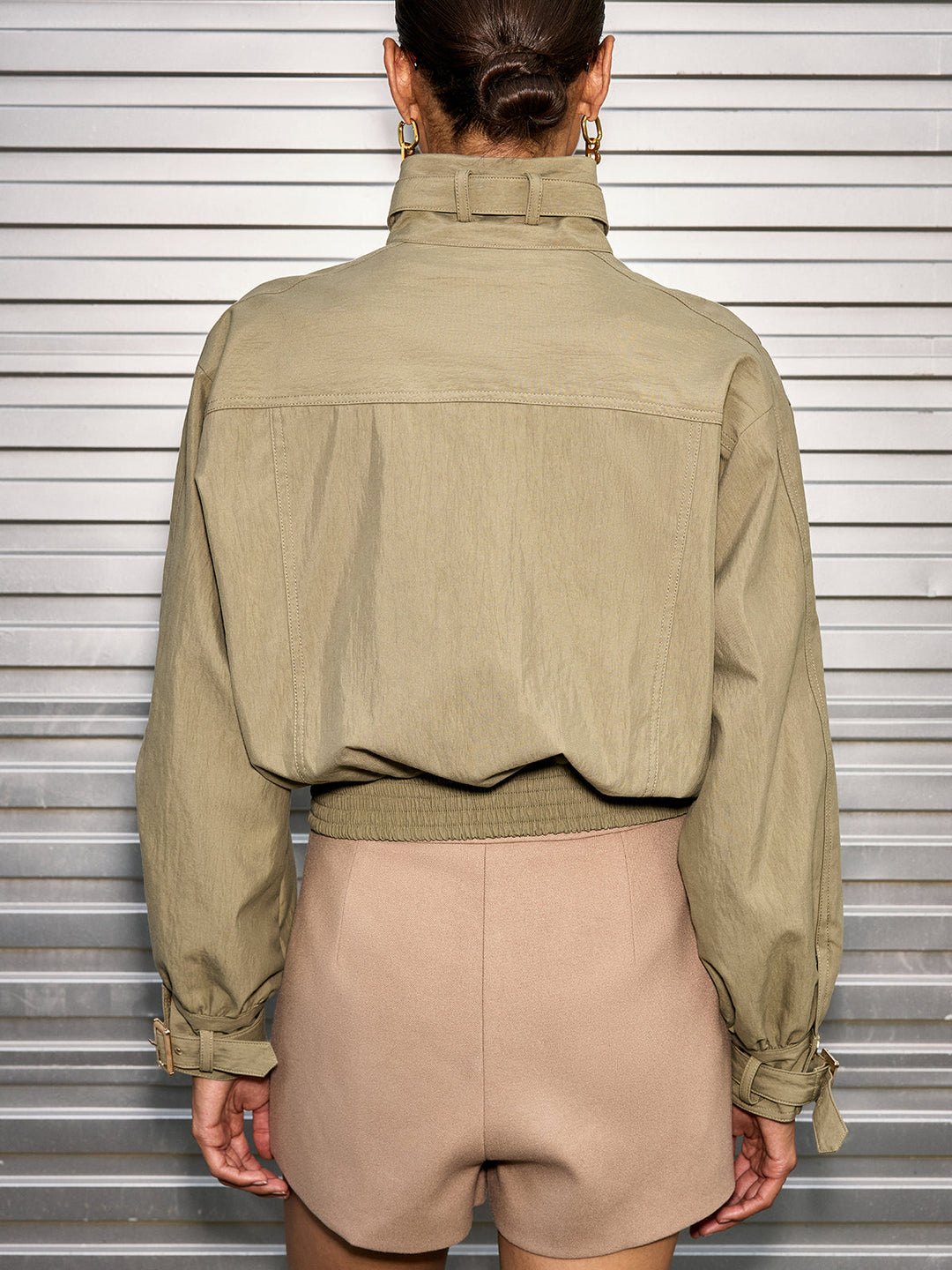 Back view of olive cropped utility jacket showing yoke seam and elasticated hem