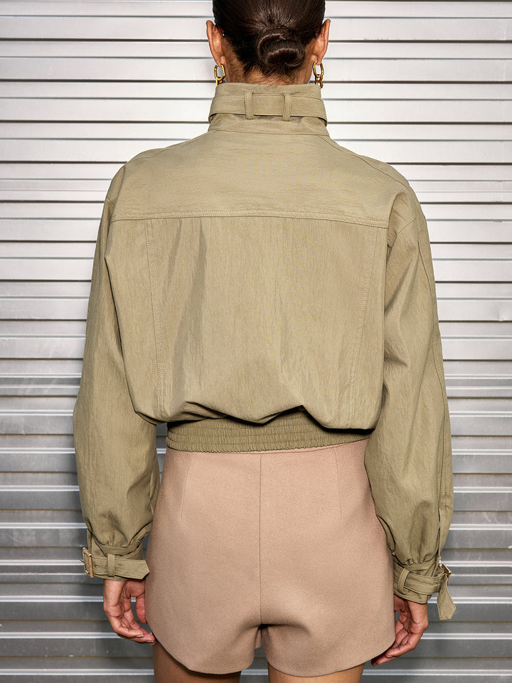 Back view of olive cropped utility jacket showing yoke seam and elasticated hem