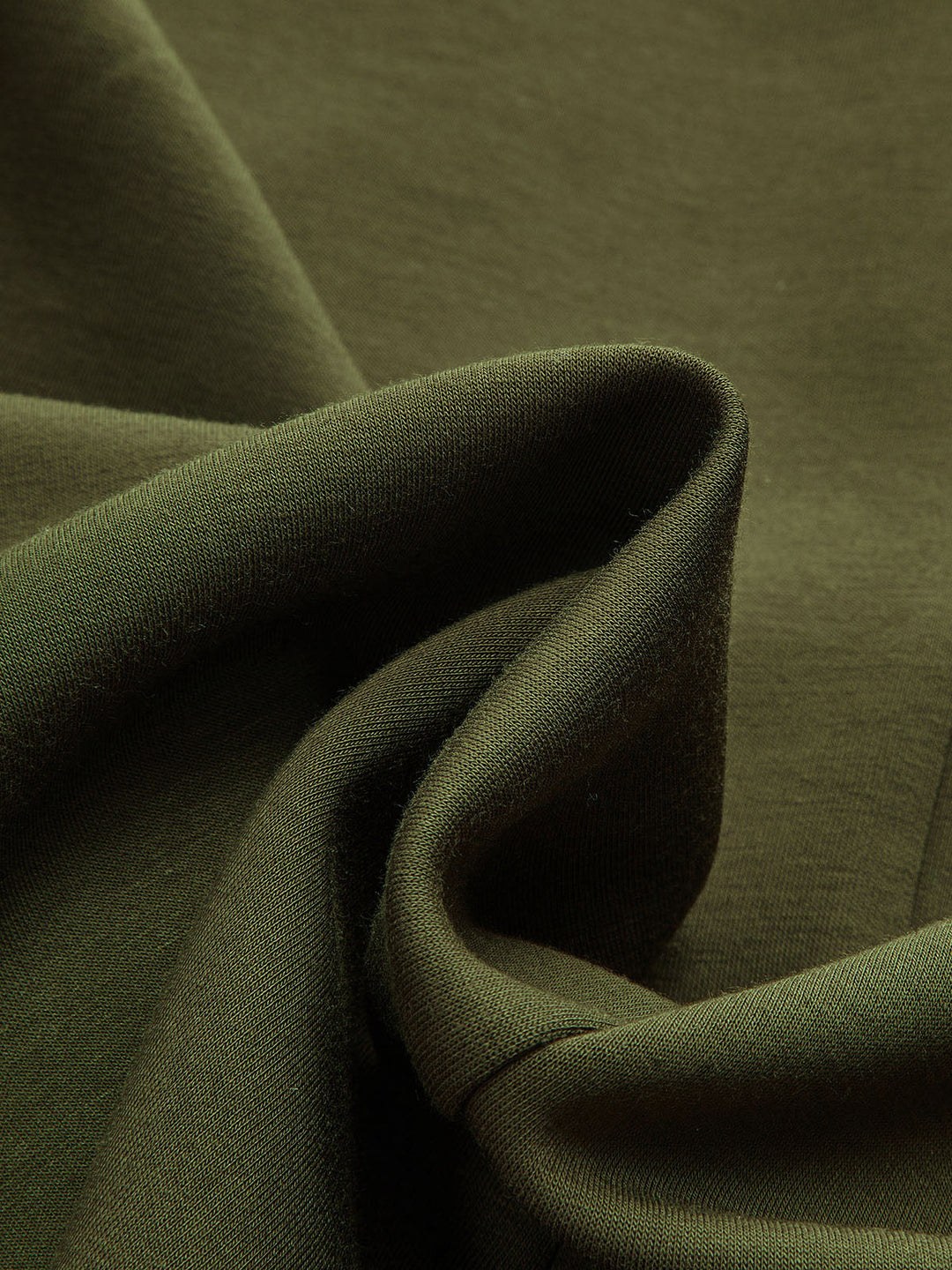 Macro shot of soft dark green knit fabric of the longline V-neck cardigan