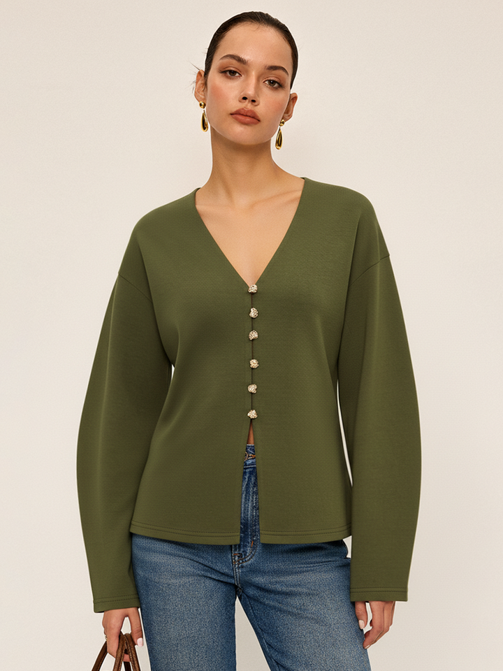 Model wears dark olive green V-neck longline cardigan with gold buttons and blue jeans, front view