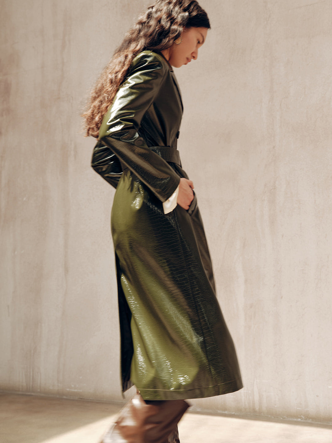 Profile shot of the gradient green PU trench coat catching the light on the sleeve