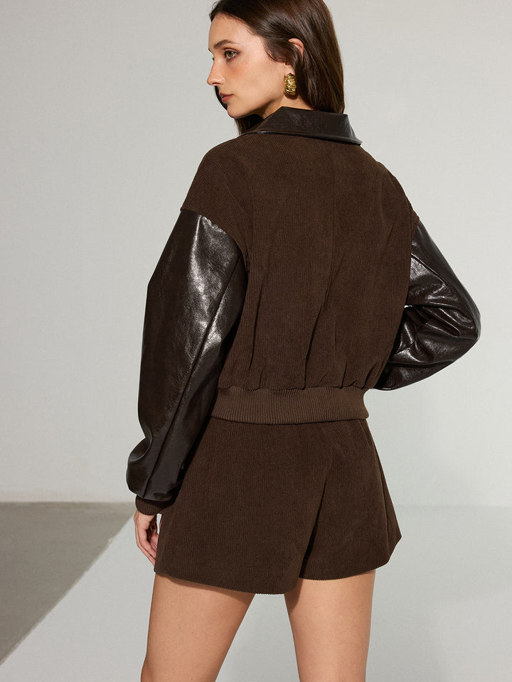 Back view of corduroy panel jacket showing faux leather sleeves and elastic waistband