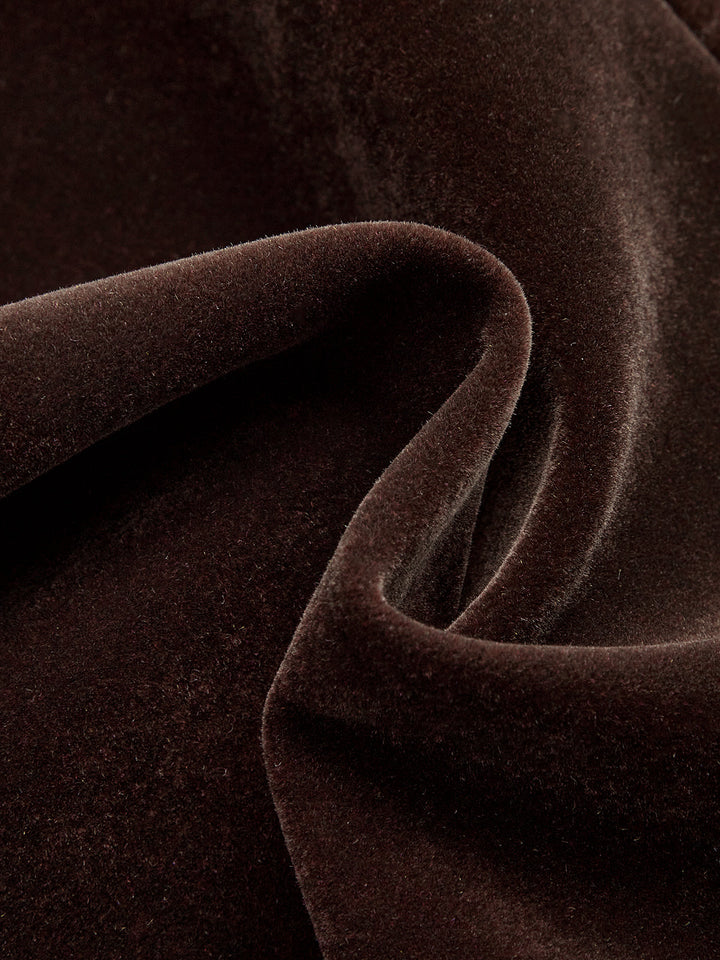 Swirled close-up of the plush dark brown velvet fabric