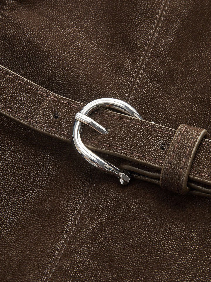 Close-up of silver horseshoe buckle on brown distressed faux leather belt