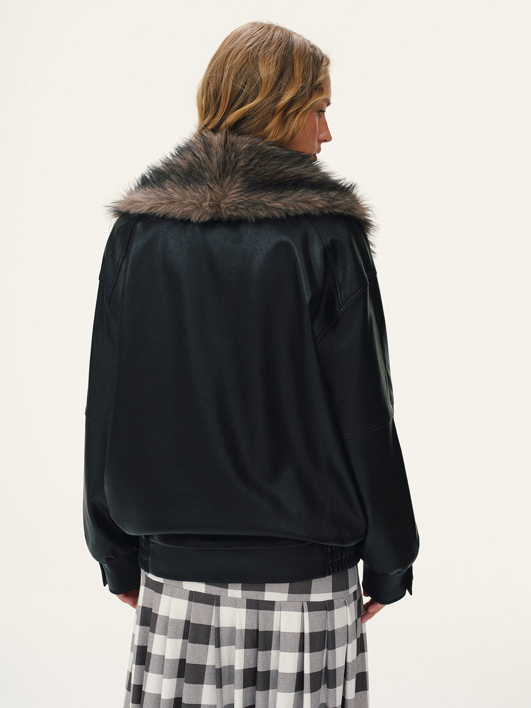 Back view of the oversized black leather bomber showing the fur collar from behind