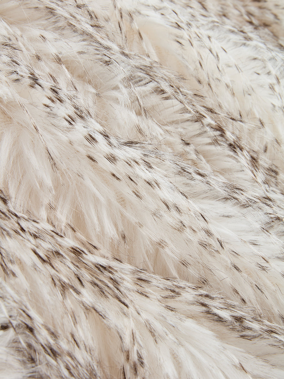 Macro of the long speckled cream and brown faux fur pile of this belted vest