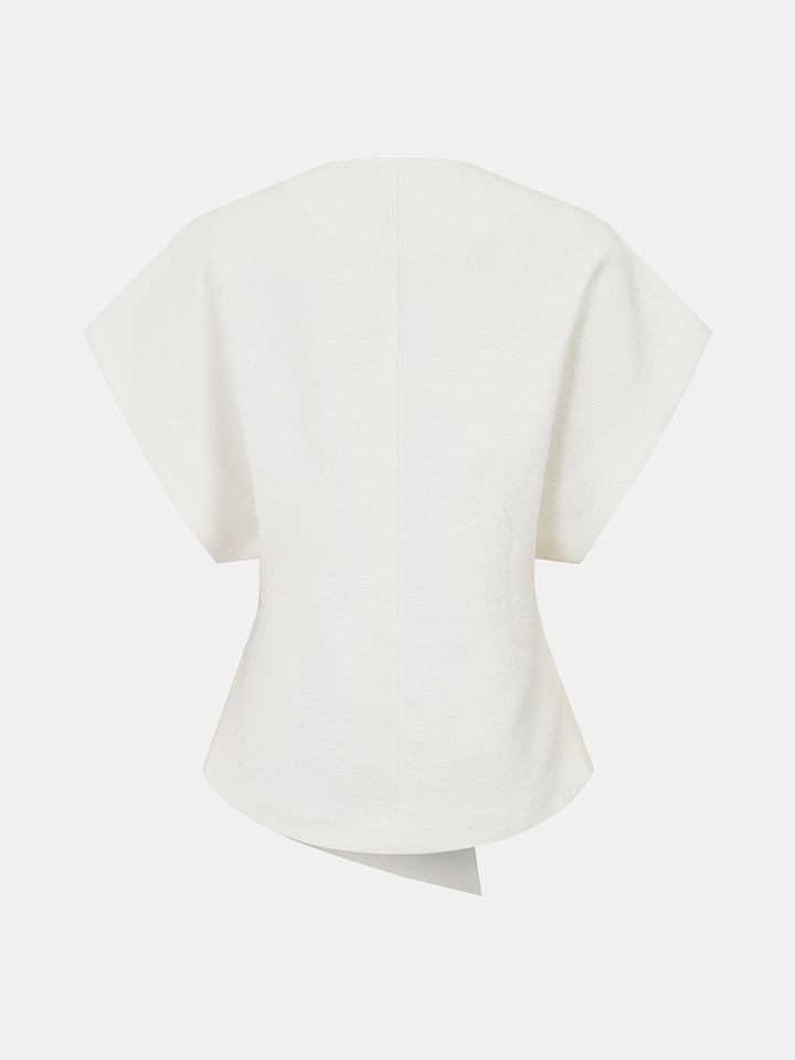 Back view of the ivory textured short sleeve top with wide shoulders and asymmetric hem