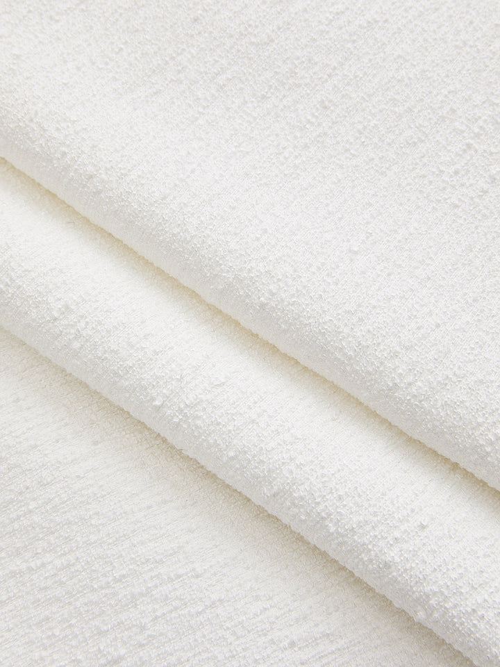 Macro of the white boucle textured fabric used for this jeweled short sleeve top