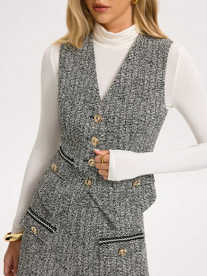 Close view of gold metal buttons and contrast braid trim on grey tweed vest
