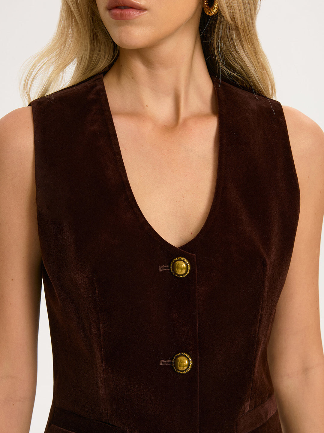 Close-up of the deep V-neckline and two antique gold buttons on the chocolate velvet vest
