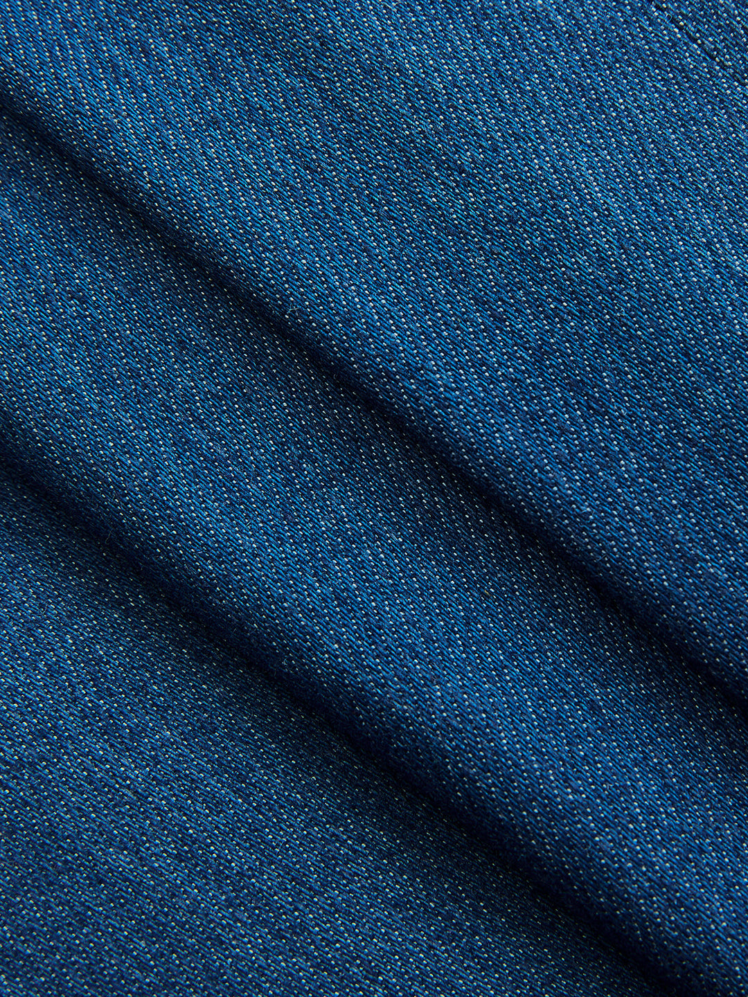 Macro of the blue denim twill weave of this women's wrap tie waist vest