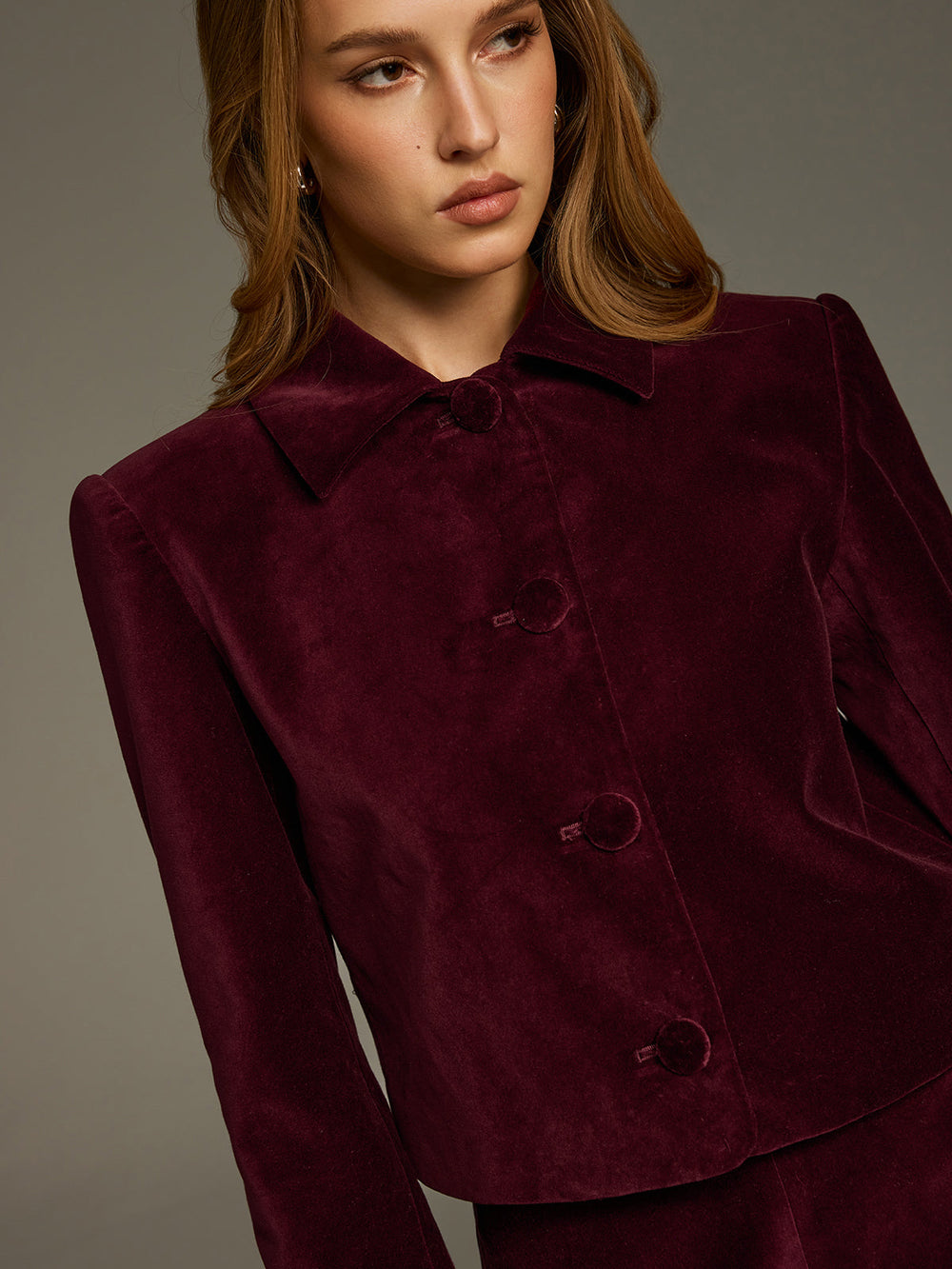 Close-up of the wine velvet jacket showing the oversized collar and covered buttons