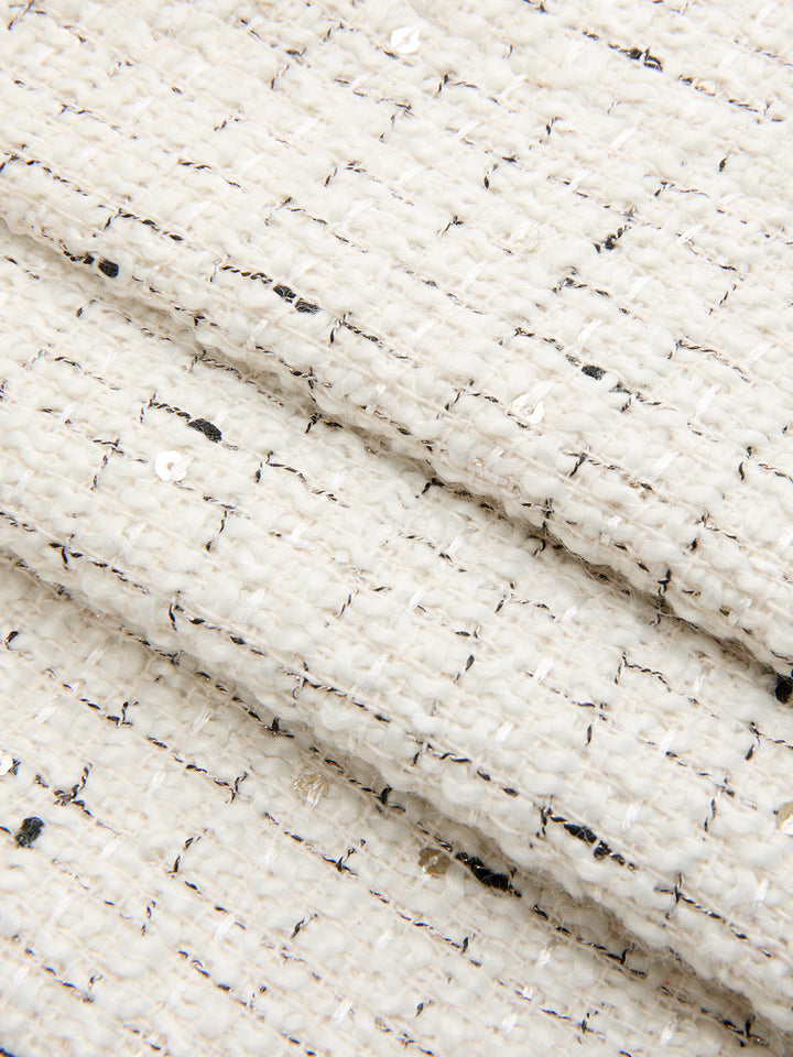 Close-up of ivory boucle tweed with metallic flecks and woven texture