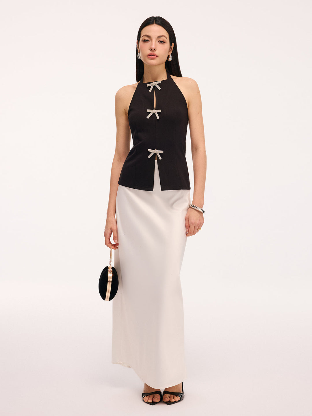 Full-length evening look with black bow halter top and ivory satin maxi skirt