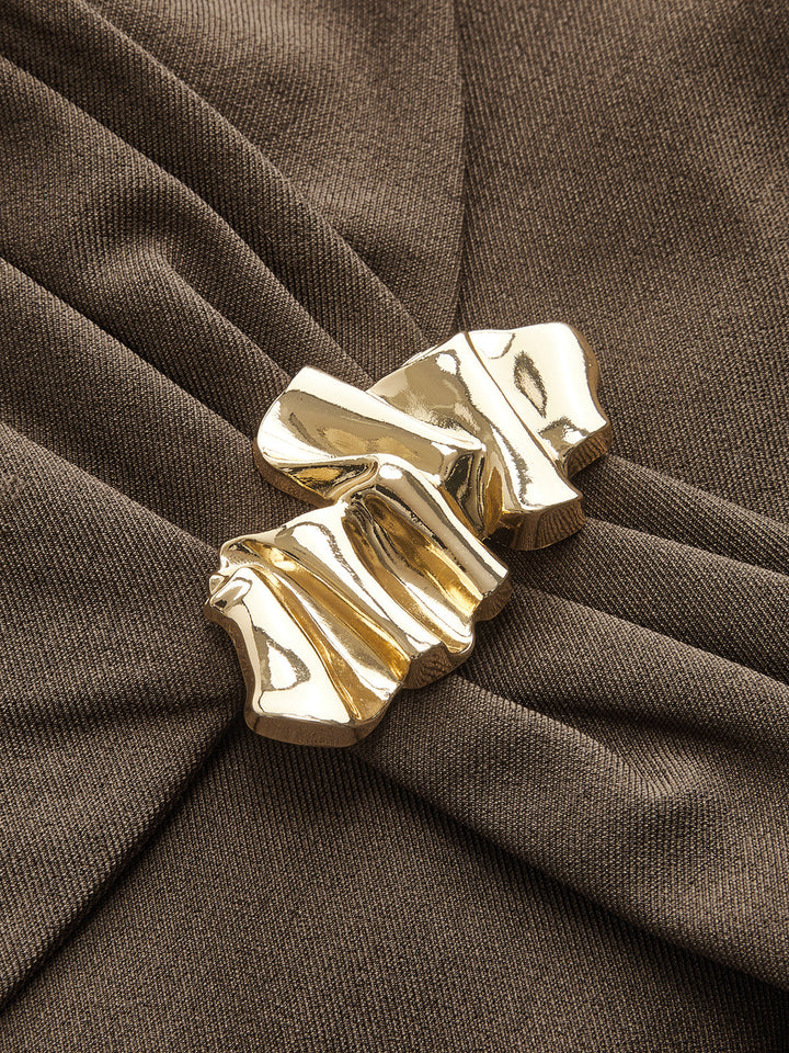 Close-up of the molten gold buckle and gathered drape on the brown vest top