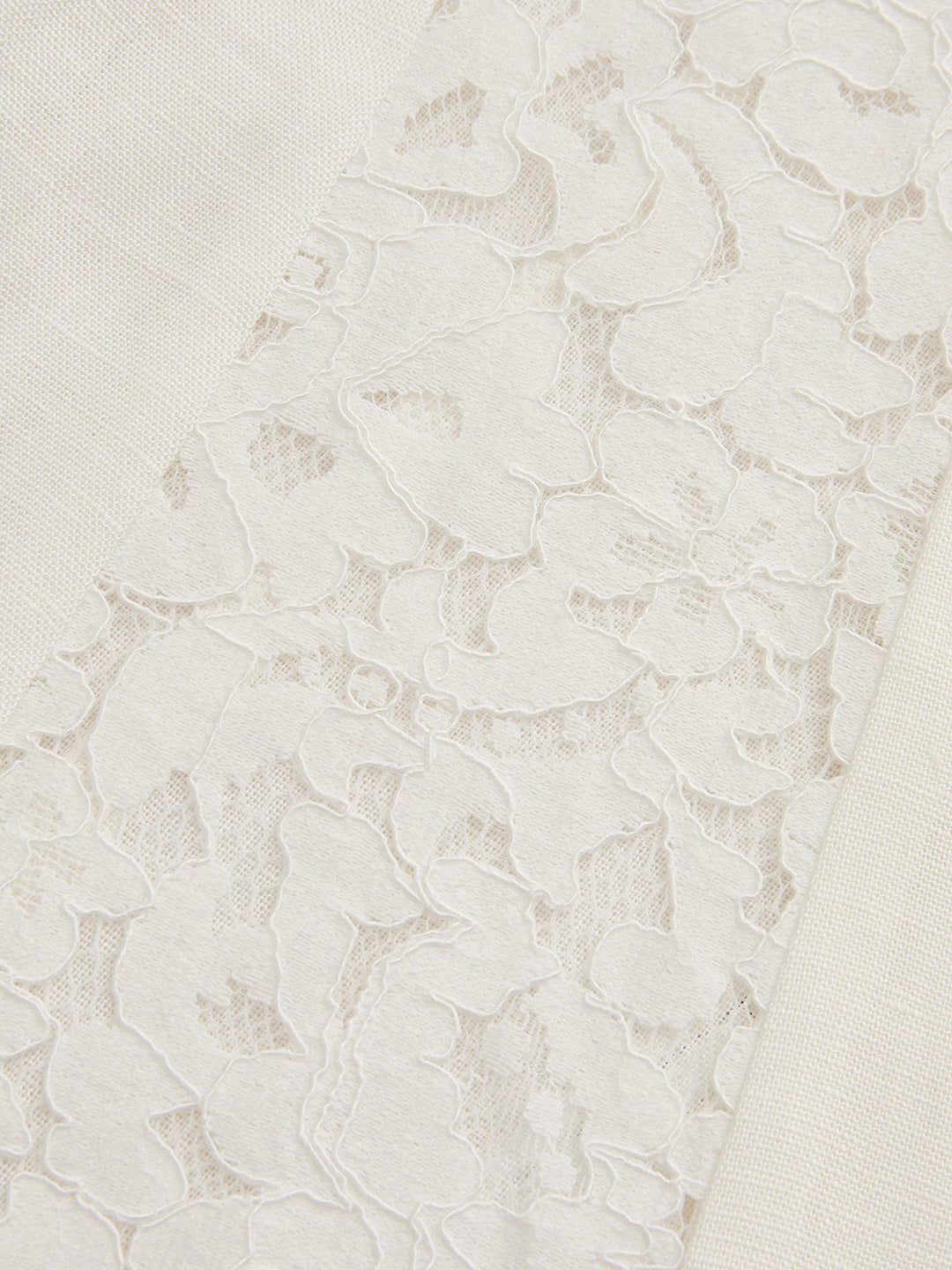 Detail of the floral lace side panel set into the cream linen blend vest