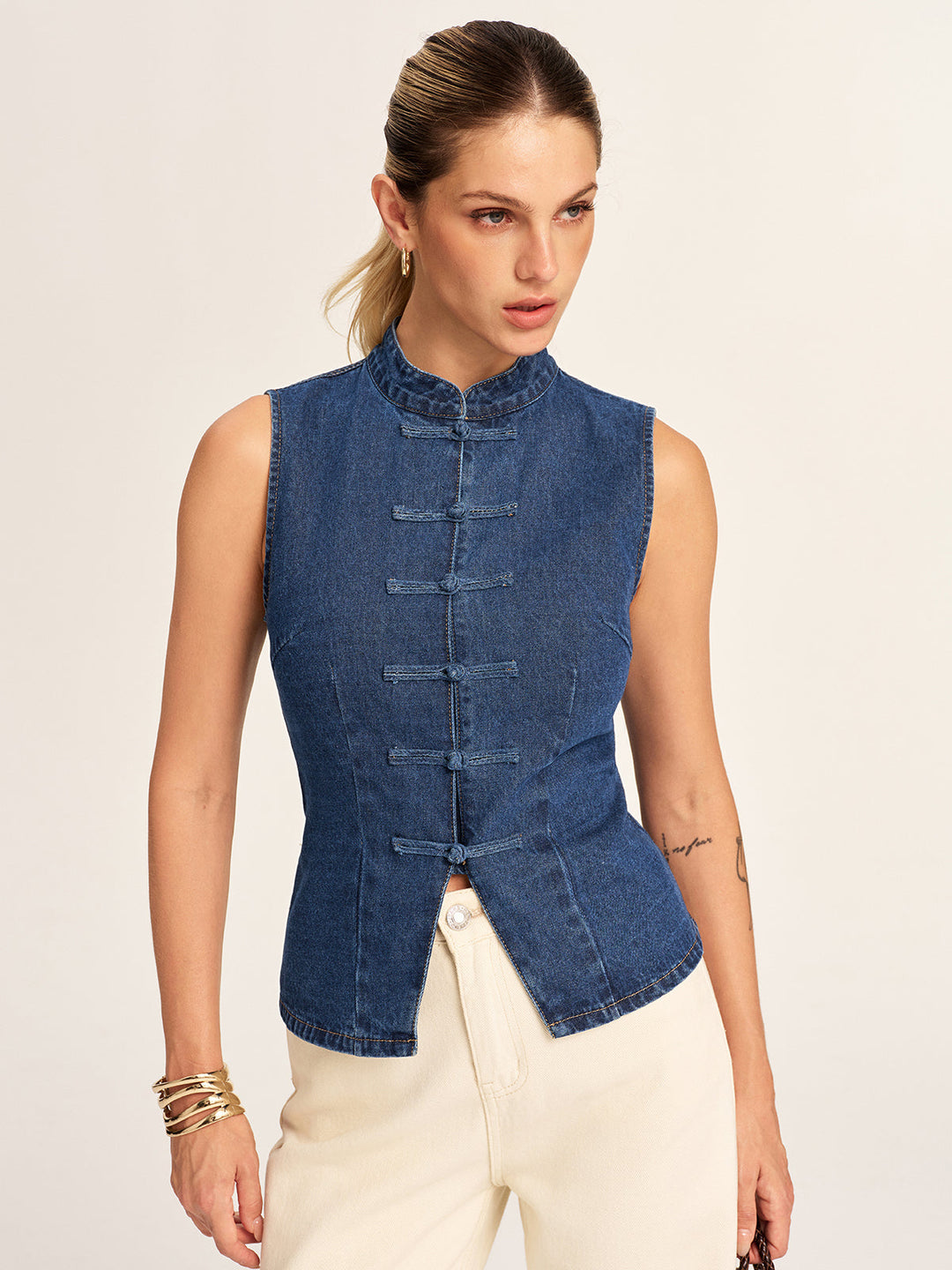 Women's sleeveless denim vest with Chinese knot buttons, front view with hands down