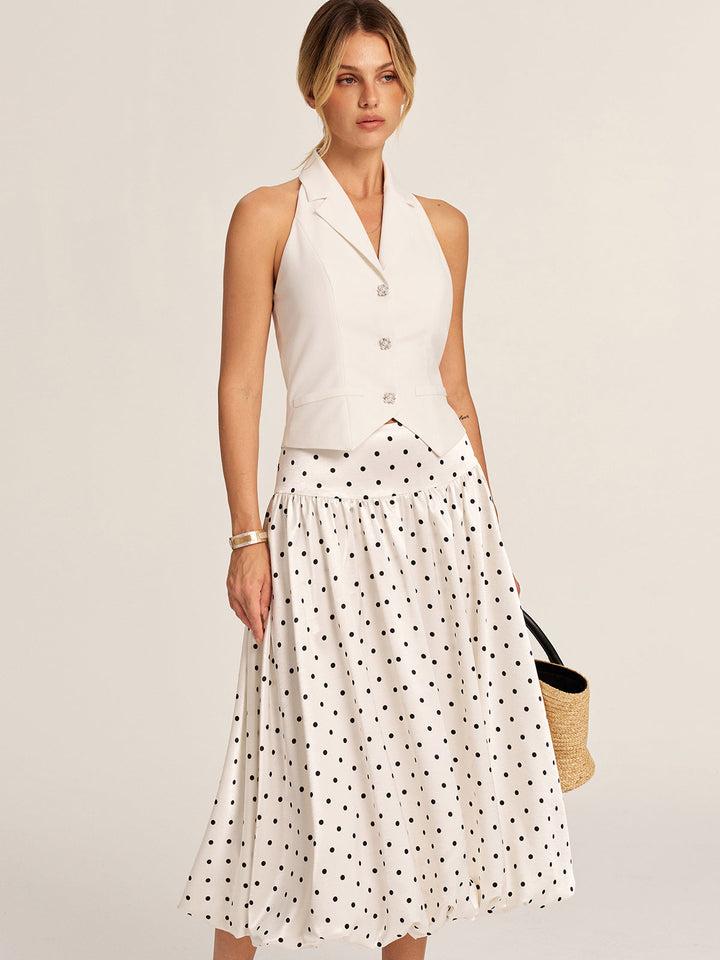 Ivory halter neck blazer vest styled with polka dot midi skirt and straw bag, full outfit shot