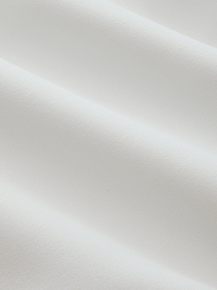 Macro of the smooth white crepe fabric used in the colour block stand collar vest