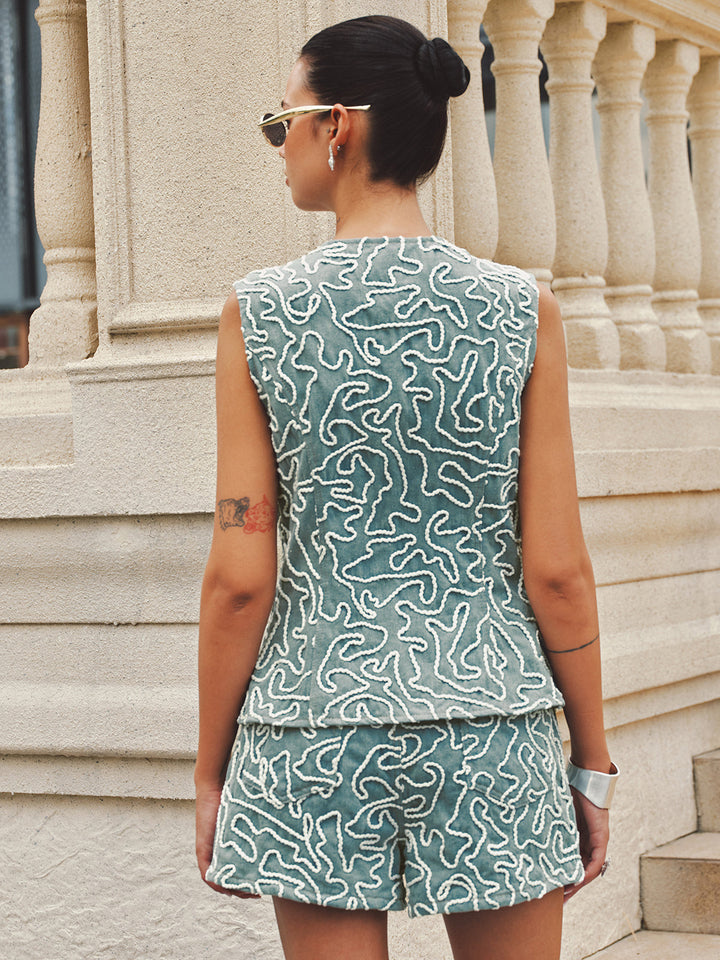 Back view of the sleeveless denim vest and shorts showing the all-over cord embroidery