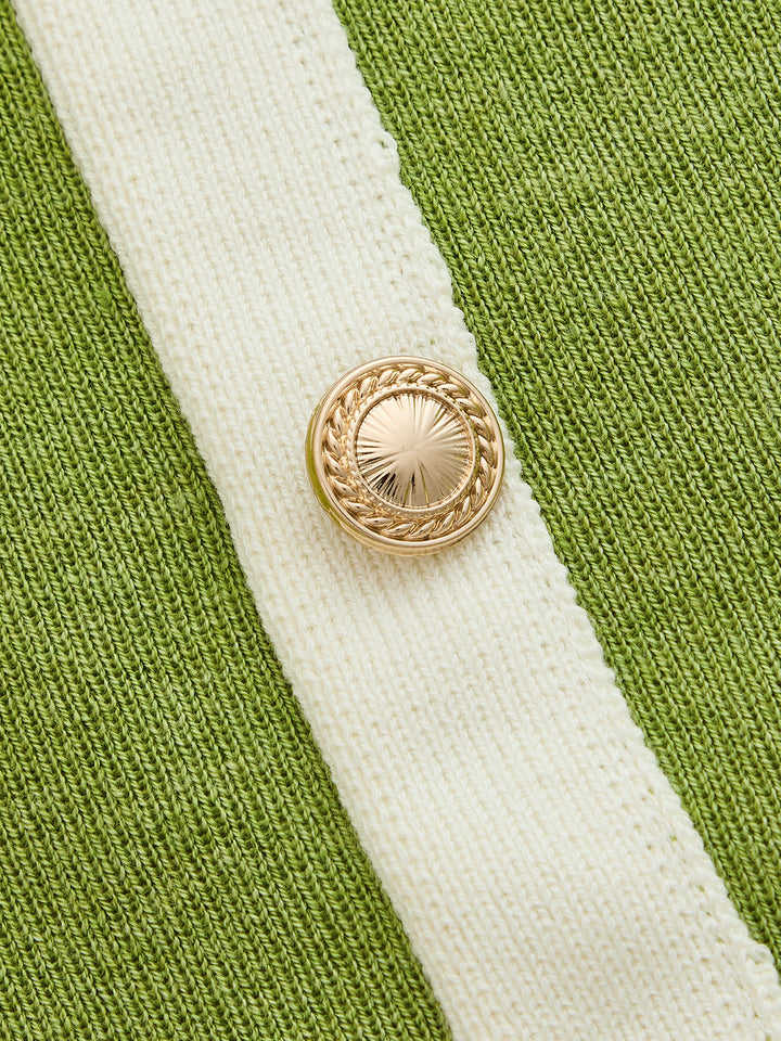 Close-up of the gold rope effect button on the ivory placket of the green knit dress