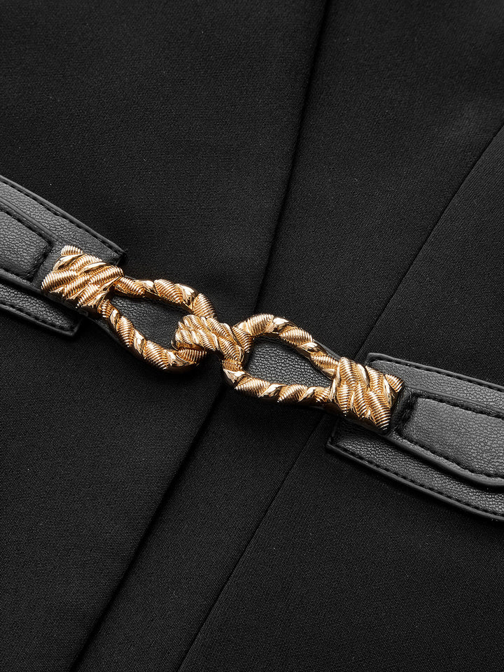 Close-up of twisted gold rope buckle on the black leather waist belt of the sleeveless top