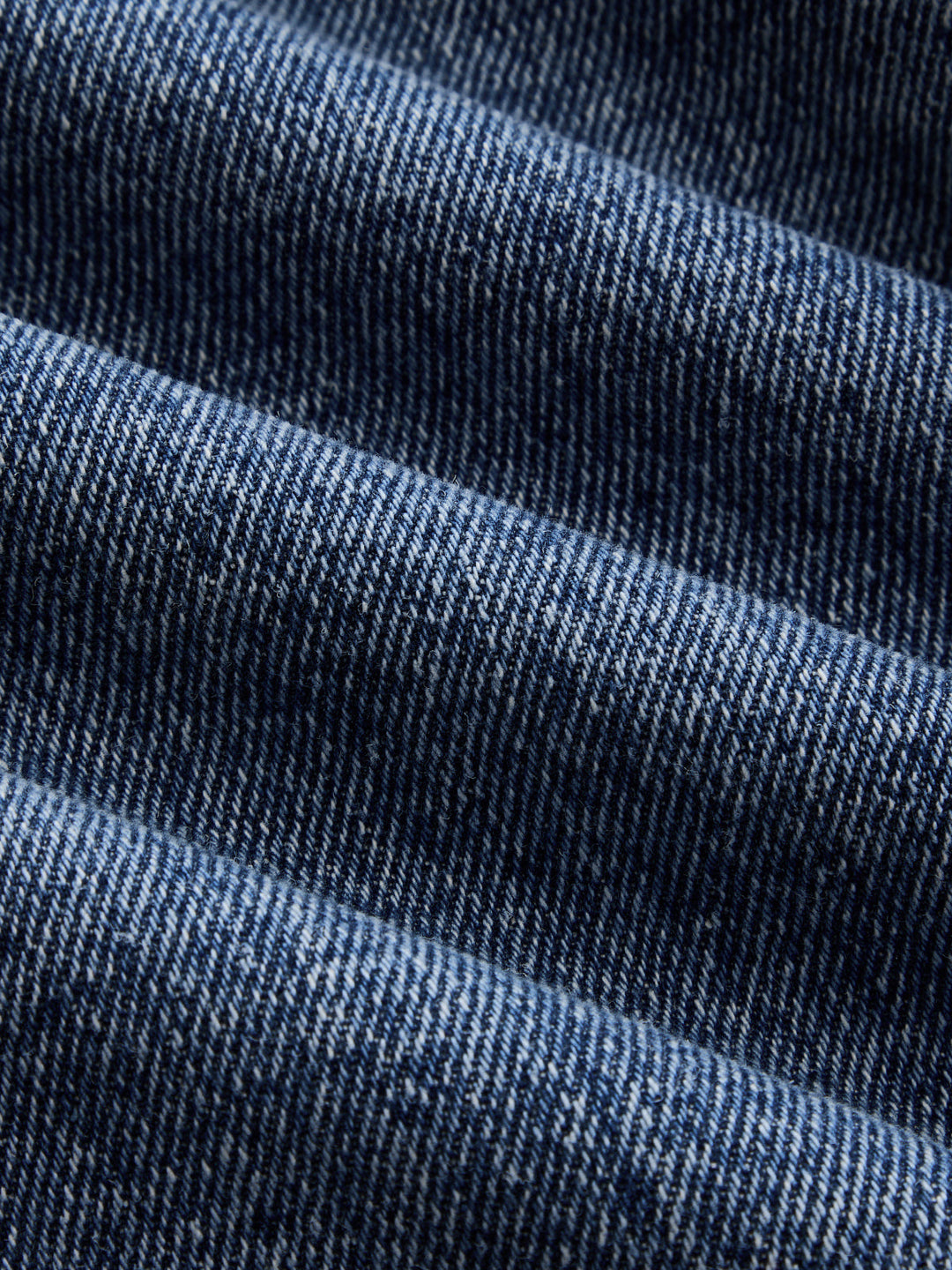 Texture close-up of the faded indigo denim twill