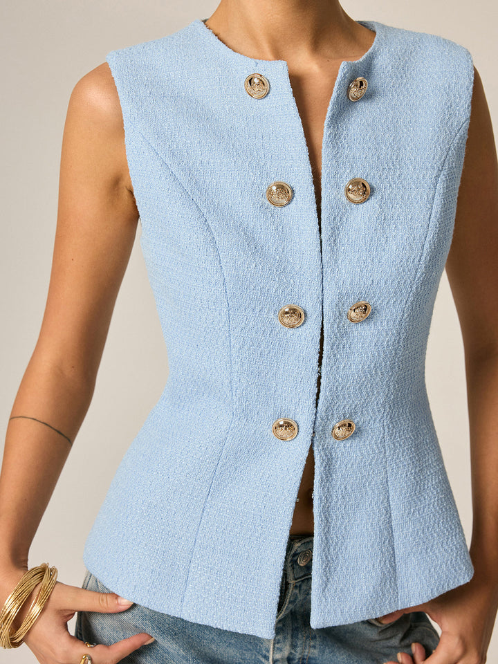 Close-up of the blue tweed sleeveless vest showing gold metal buttons and princess seams