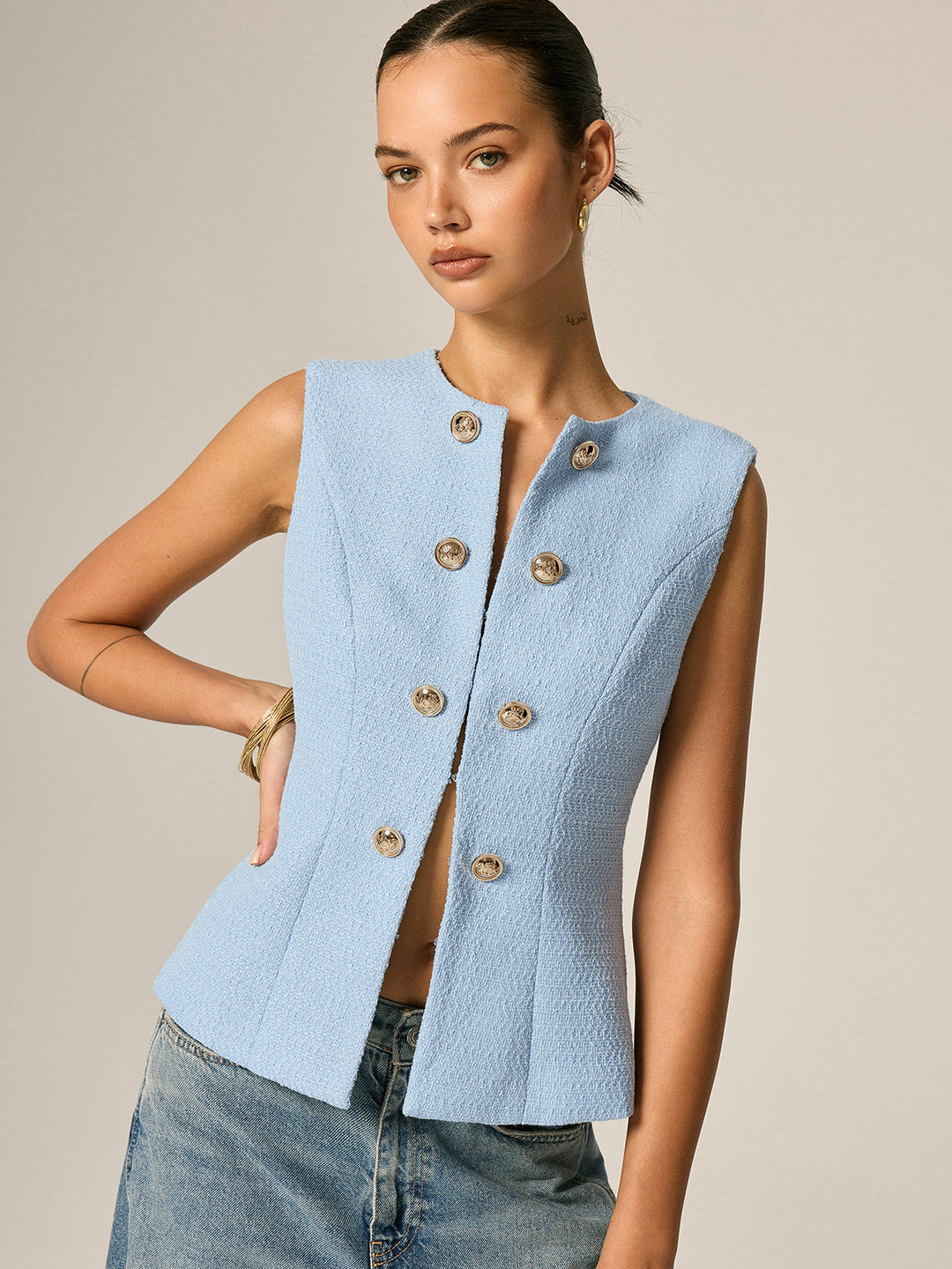 Angled front view of the gold button tweed vest showing the open front and fitted waist